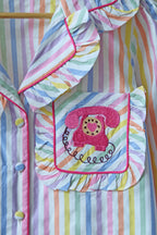 Colorful striped shirt with a pink phone design on a wooden hanger